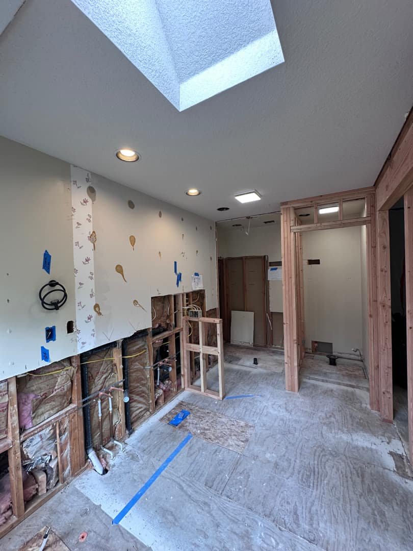 Partially finished interior with exposed wiring and recessed lighting installation in progress.