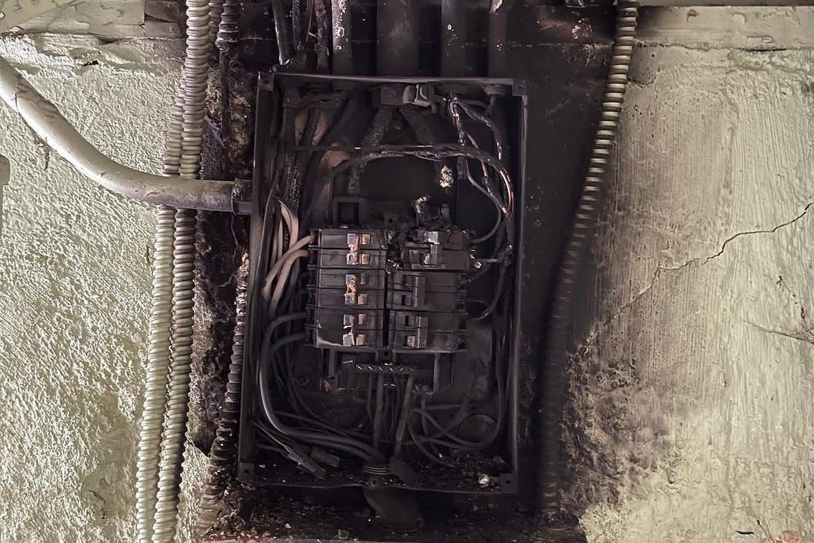 Charred wiring and a failed electrical panel in an older Vancouver, WA home before replacement by Power Professor