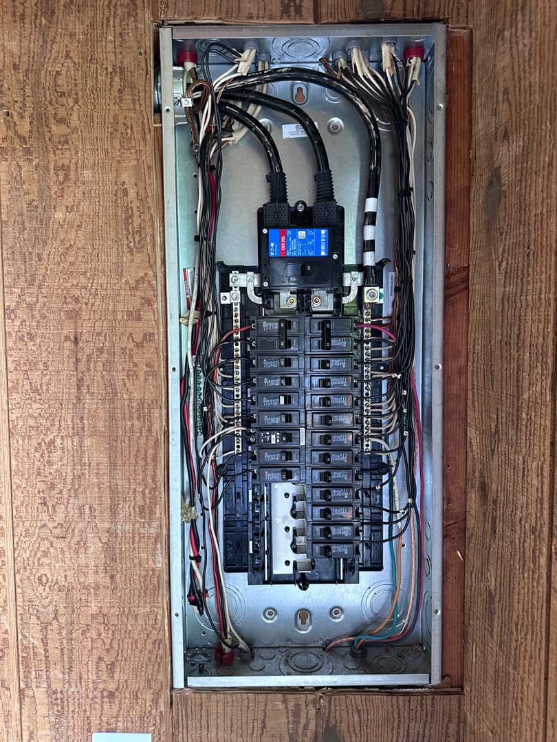 Well-organized electrical panel with circuit breakers and neat wiring.
